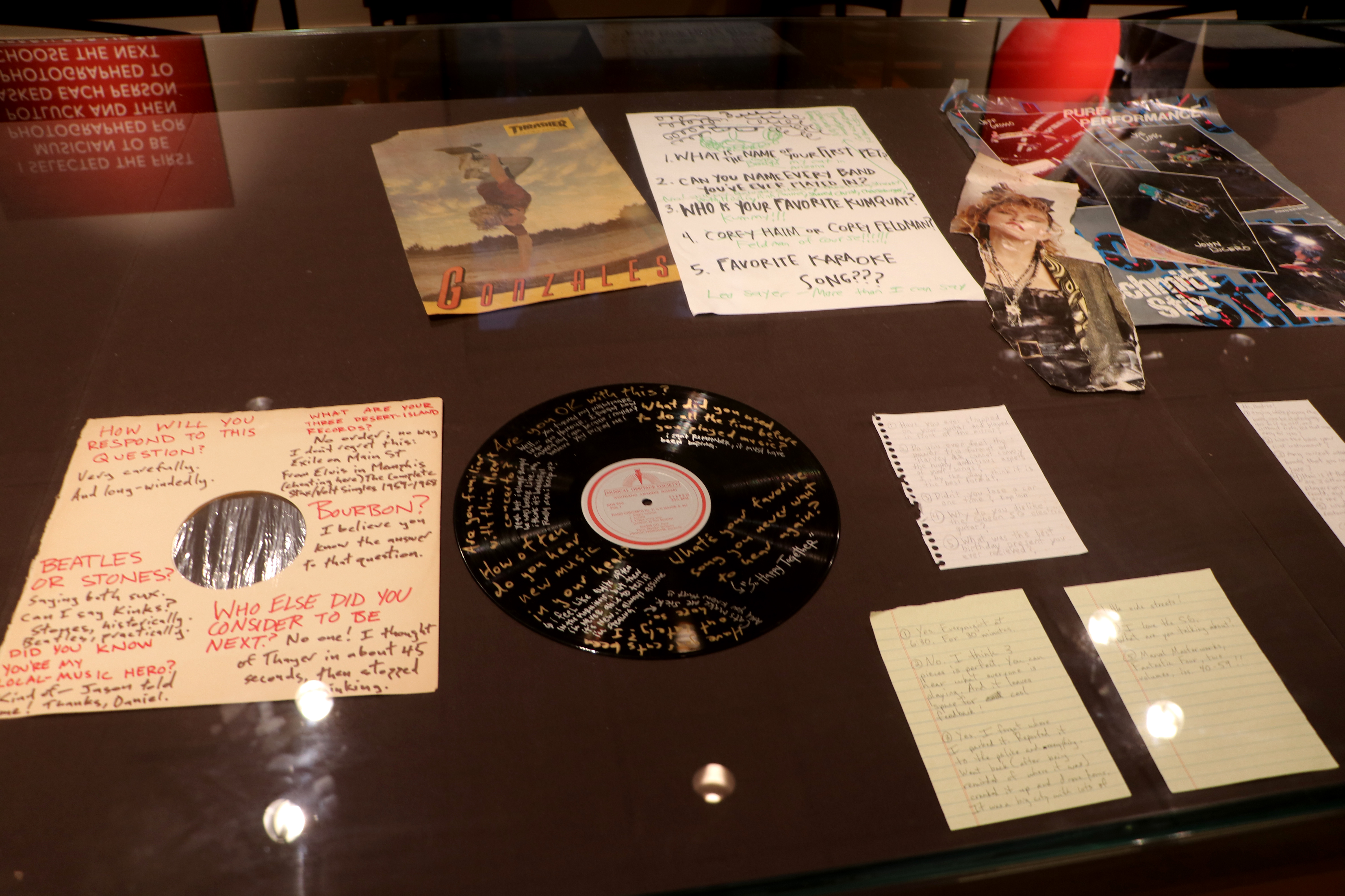 A Q&A with a musician written on a record vinyl and its white paper sleeve in an exhibit case