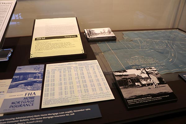 A display cabinet showing government publications and photos relating to housing