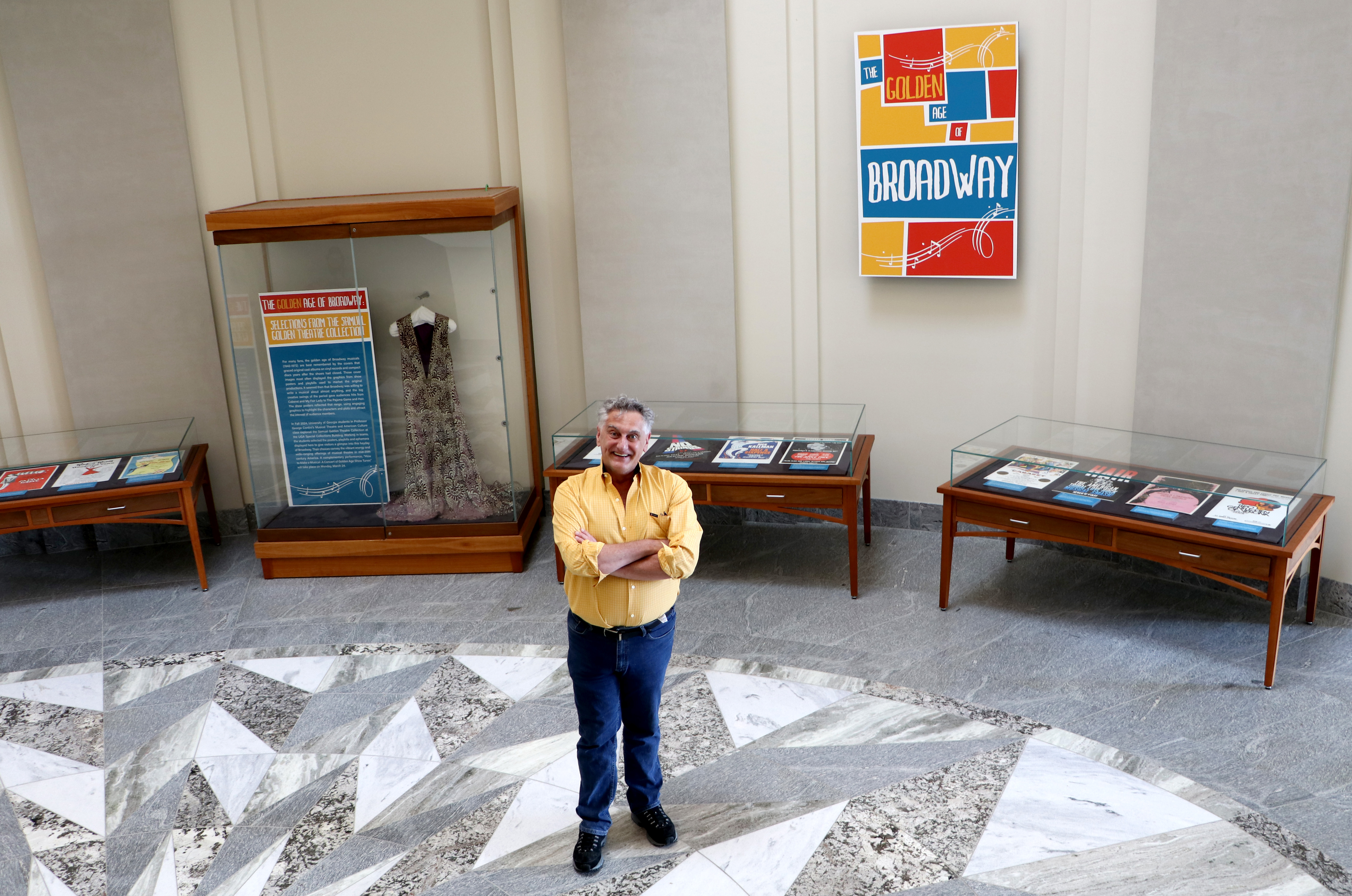 George Contini smiling in front of exhibit