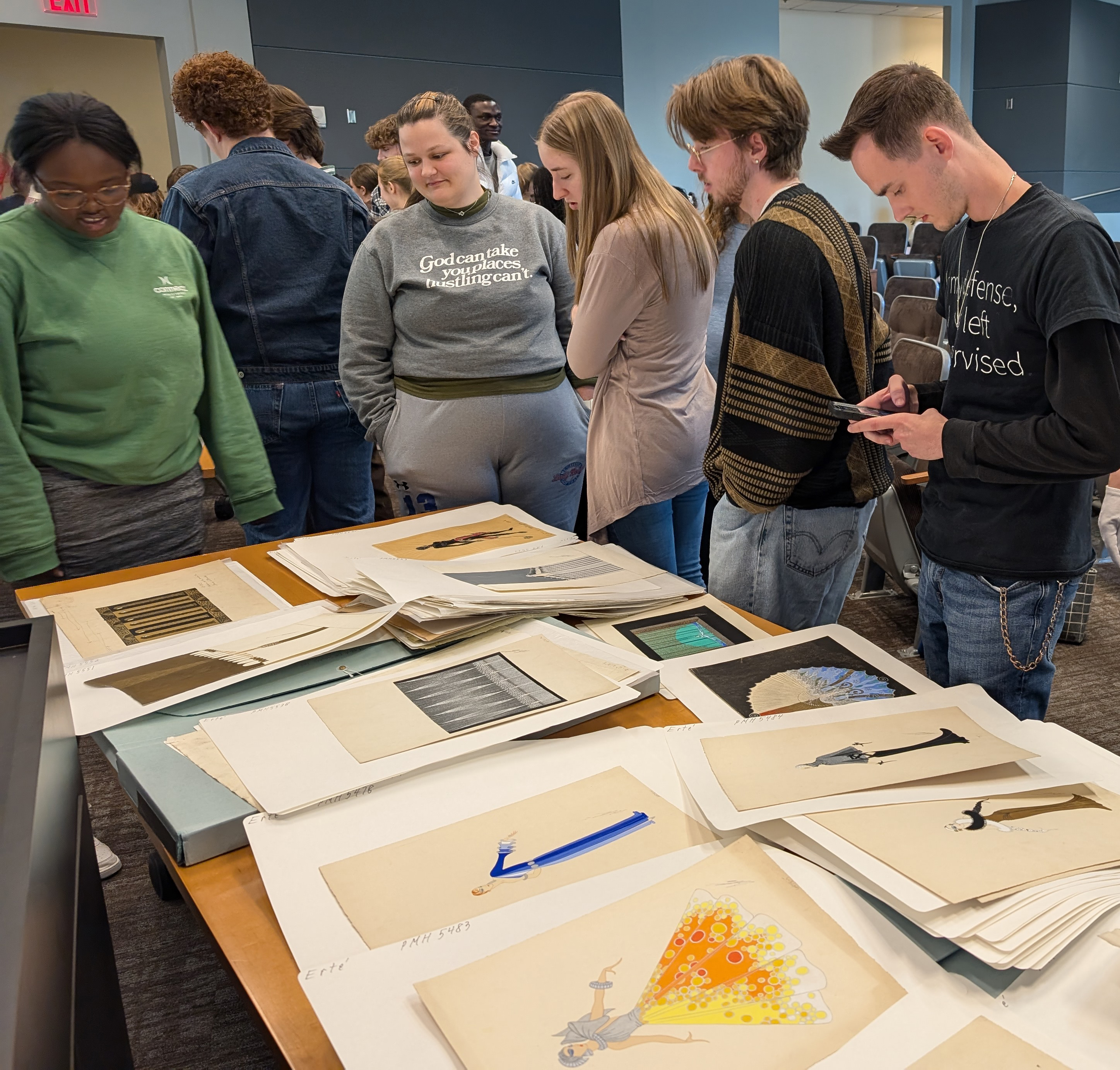 Students look at costume designs