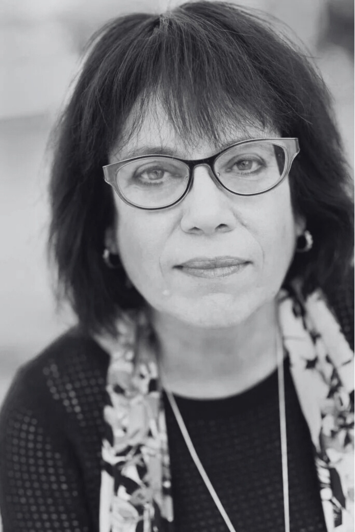 Black and white photo of a woman with glasses and a scarf