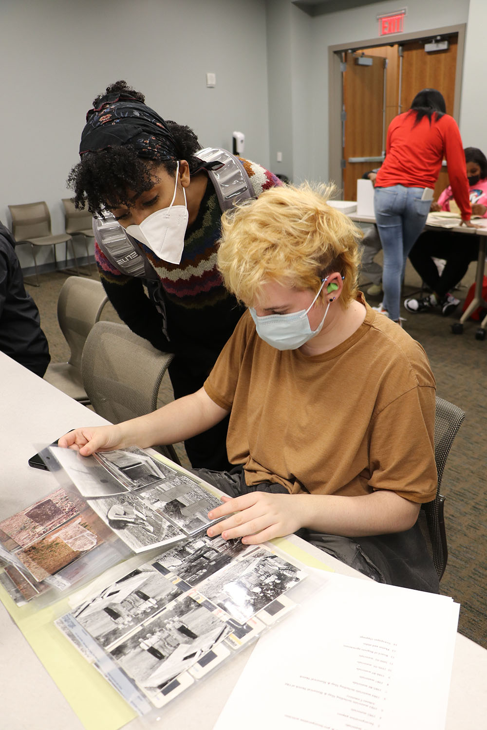 Two students examine a series of original photographs