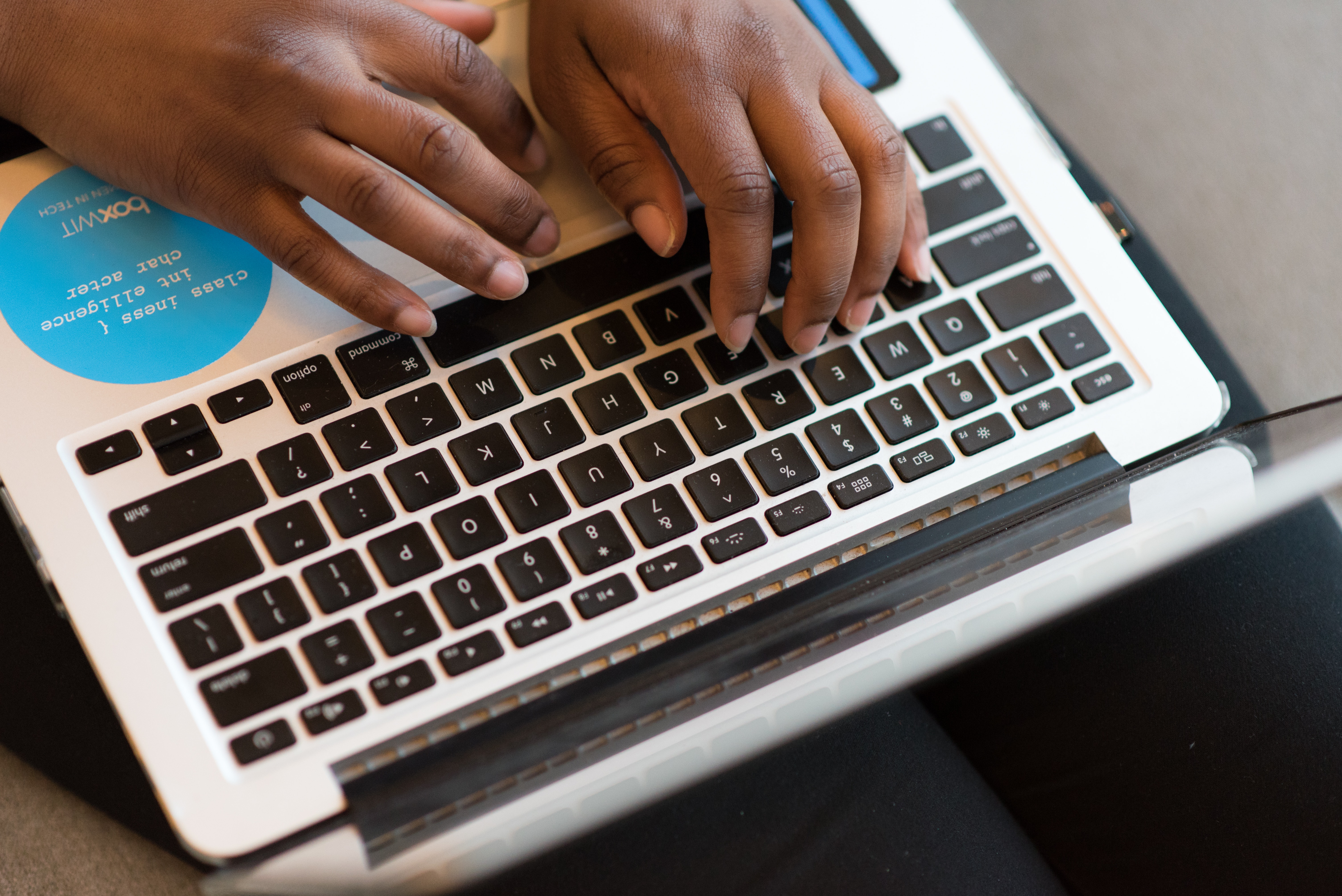 close-up of laptop with hands typing