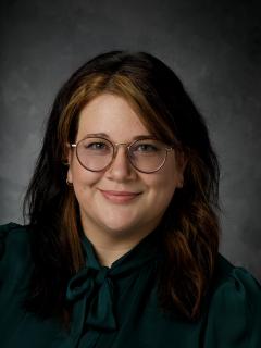 Woman Smiling with glasses and a dark shirt