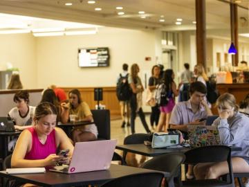 Students sitting at tables in the Jittery Joe's coffee shop at the MLC.